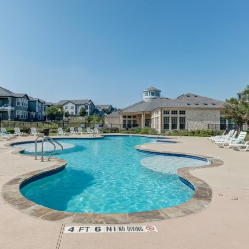 a swimming pool with lounge chairs around it